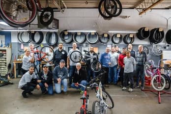 Equipo de voluntarios de Qualitrol con bicicletas reparadas para donación